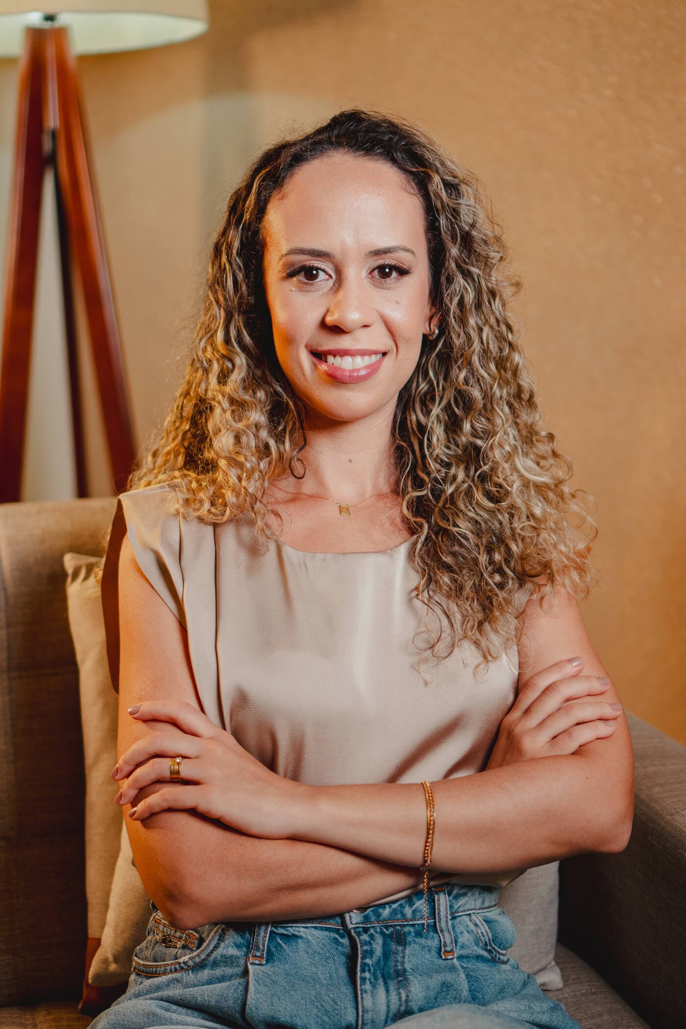 Camila Rosa, psicóloga clínica, sentada em seu consultório com expressão serena e acolhedora