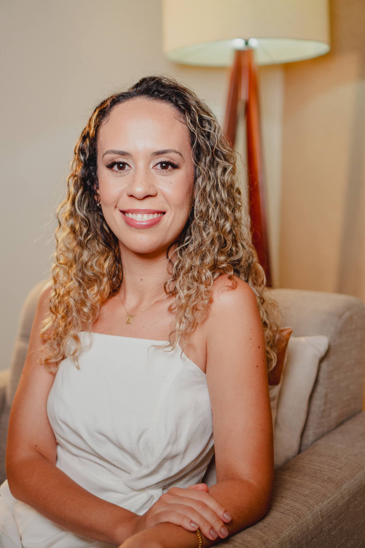 Camila Rosa, psicóloga clínica, sentada sob luz quente de fim de tarde, com expressão acolhedora